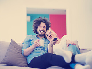 Image showing Young couple on the sofa watching television