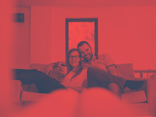 Image showing Young couple on the sofa watching television