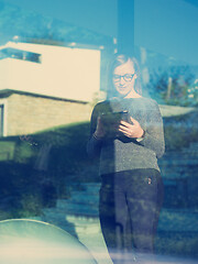 Image showing Woman using tablet at home by the window