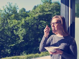 Image showing woman eating breakfast in front of her luxury home villa