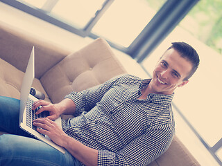 Image showing Man using laptop in living room