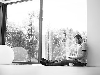 Image showing man drinking coffee on the floor enjoying relaxing lifestyle