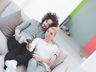 Image showing Young couple on the sofa watching television