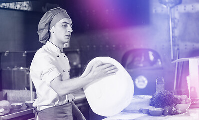 Image showing chef throwing up pizza dough