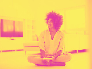 Image showing black women using tablet computer on the floor at home