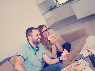 Image showing couple eating pizza in their luxury home villa