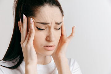 Image showing Woman having headache. Isolated over gray background.