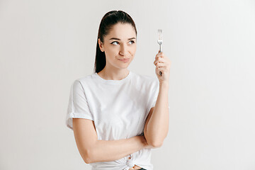 Image showing Young fun crazy brunette housewife with fork isolated on white background