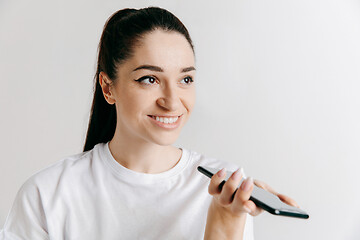 Image showing Indoor portrait of attractive young woman holding blank smartphone