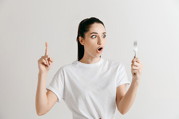 Image showing Young fun crazy brunette housewife with fork isolated on white background