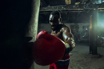 Image showing Hand of boxer over black background. Strength, attack and motion concept