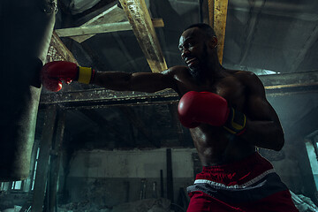 Image showing Hand of boxer over black background. Strength, attack and motion concept