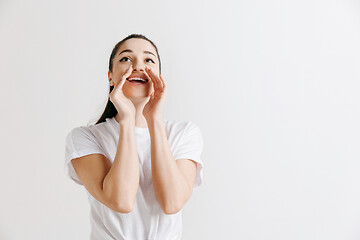 Image showing Isolated on gray young casual woman shouting at studio