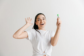 Image showing Smiling young woman looking on pregnancy test