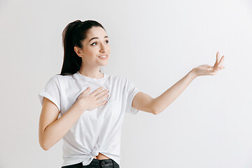 Image showing The happy woman standing and smiling against gray background.