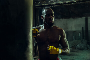 Image showing Hand of boxer over black background. Strength, attack and motion concept