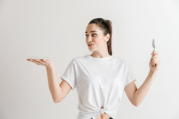 Image showing Young fun crazy brunette housewife with fork isolated on white background