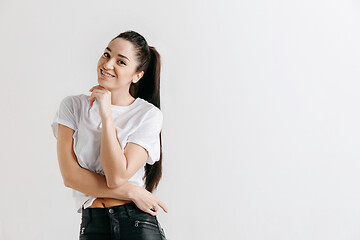 Image showing The happy woman standing and smiling against gray background.