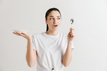 Image showing Young fun crazy brunette housewife with spoon isolated on white background