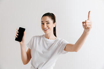 Image showing Portrait of a confident casual girl showing blank screen of mobile phone