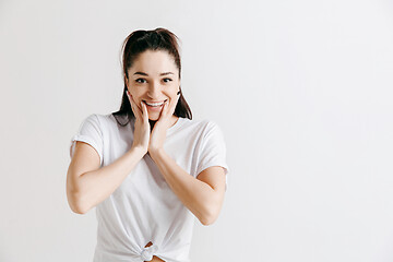 Image showing The happy woman standing and smiling against gray background.