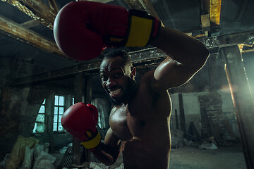 Image showing Hand of boxer over black background. Strength, attack and motion concept