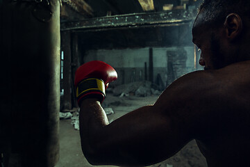 Image showing Hand of boxer over black background. Strength, attack and motion concept