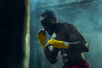 Image showing Hand of boxer over black background. Strength, attack and motion concept