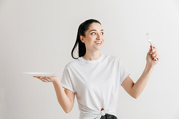 Image showing Young fun crazy brunette housewife with fork isolated on white background