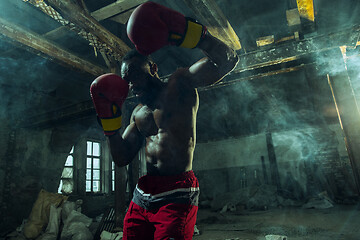 Image showing Hand of boxer over black background. Strength, attack and motion concept