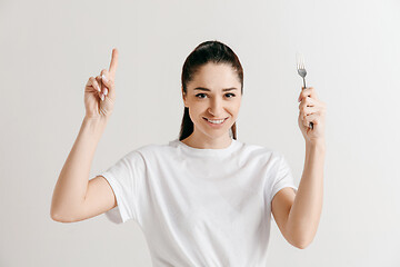 Image showing Young fun crazy brunette housewife with fork isolated on white background