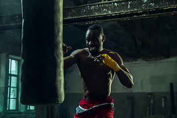 Image showing Hand of boxer over black background. Strength, attack and motion concept