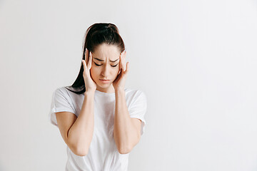 Image showing Woman having headache. Isolated over gray background.