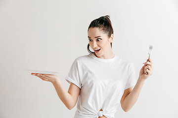 Image showing Young fun crazy brunette housewife with fork isolated on white background