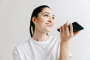 Image showing Indoor portrait of attractive young woman holding blank smartphone