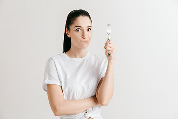 Image showing Young fun crazy brunette housewife with fork isolated on white background