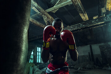 Image showing Hand of boxer over black background. Strength, attack and motion concept