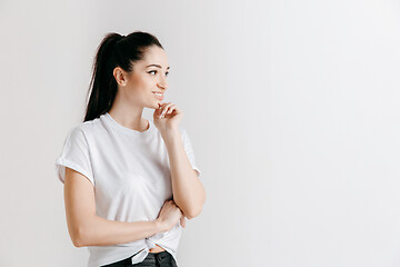 Image showing The happy woman standing and smiling against gray background.