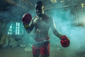 Image showing Hand of boxer over black background. Strength, attack and motion concept