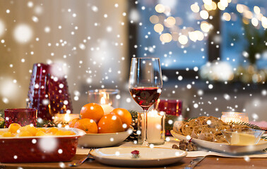 Image showing glass of red wine and food on christmas table