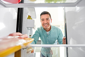 Image showing man taking food package from fridge at kitchen