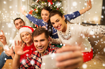 Image showing friends celebrating christmas and taking selfie