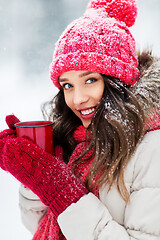 Image showing happy young woman with tea cup in winter park