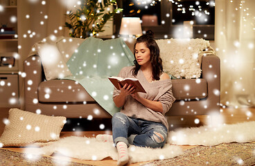 Image showing happy young woman reading book at home