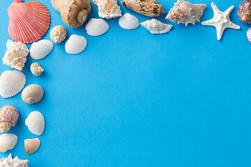 Image showing frame of different sea shells on blue background