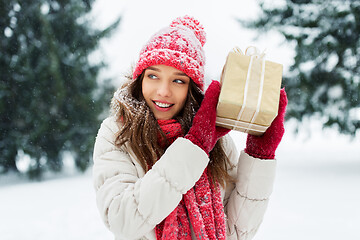 Image showing happy young woman with christmas gift in winter