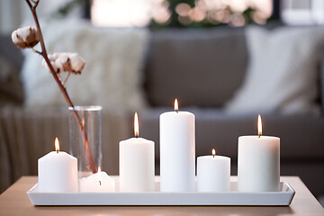 Image showing burning white candles on table at cozy home