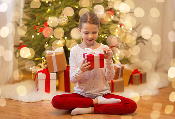 Image showing smiling girl with christmas gift at home