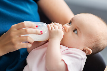 Image showing close up of mother feeding baby with milk formula