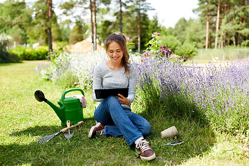 Image showing woman with tablet pc and garden tools in summer